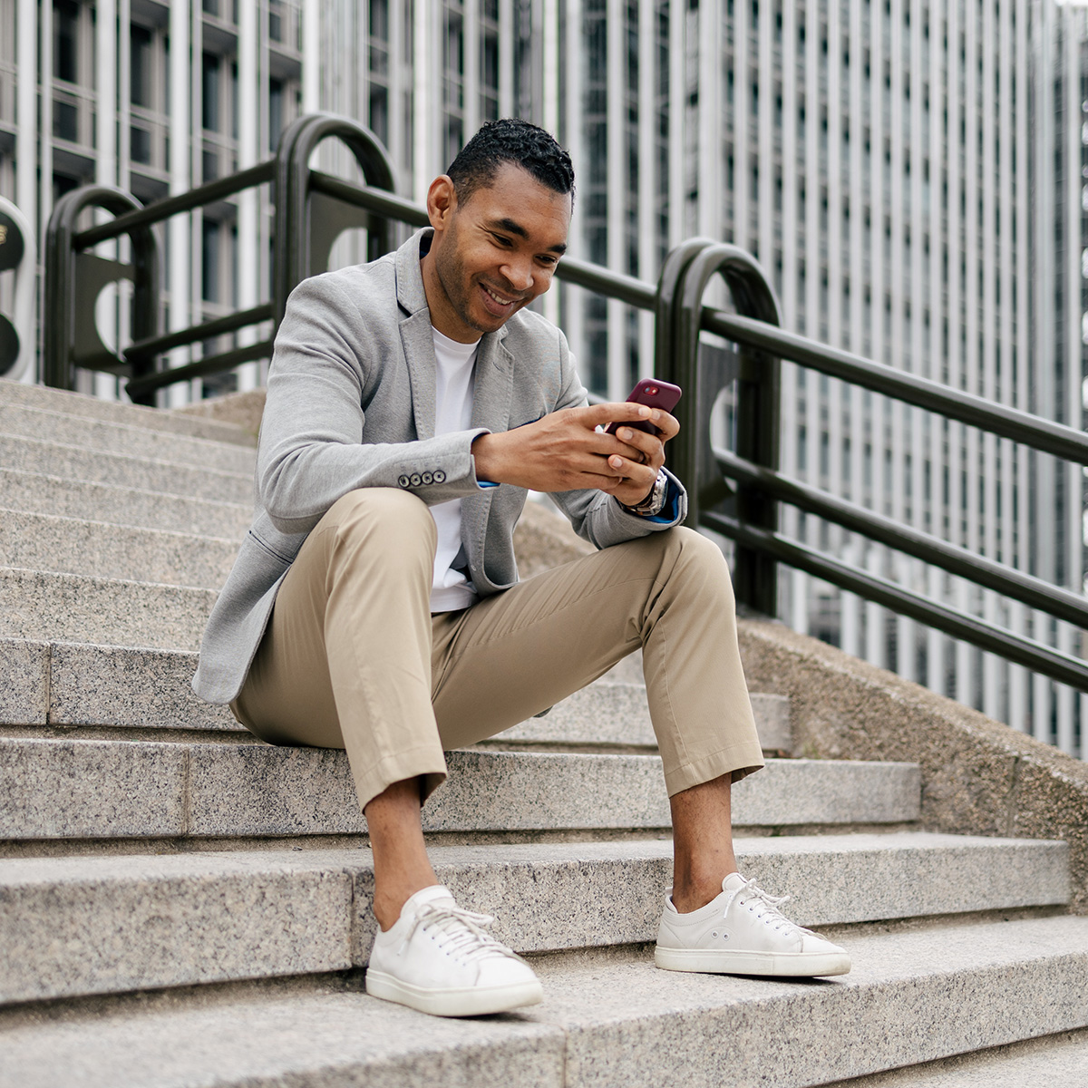 Man sitting on steps looking at his smartphone