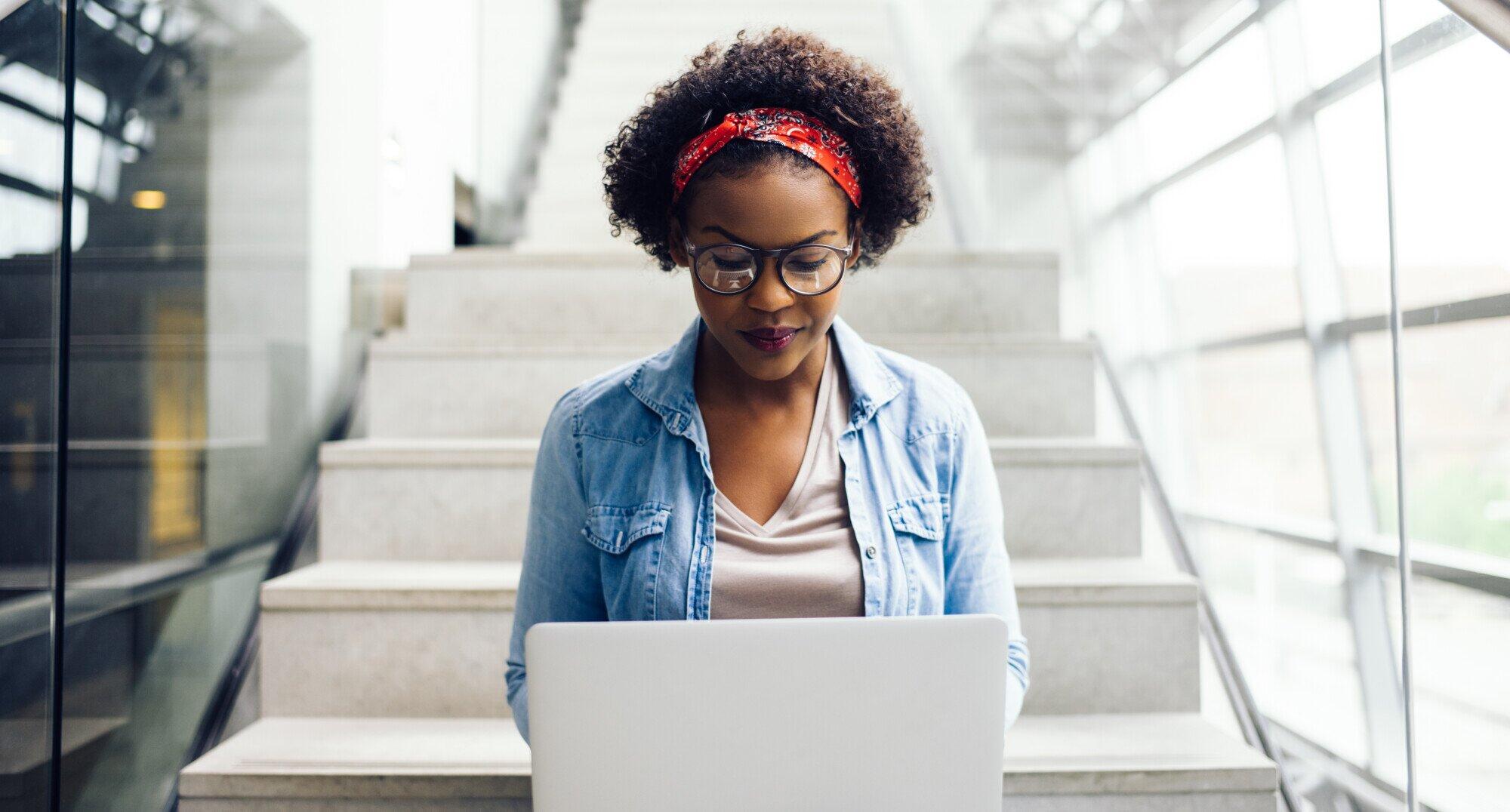 Woman on laptop researching higher education marketing agencies