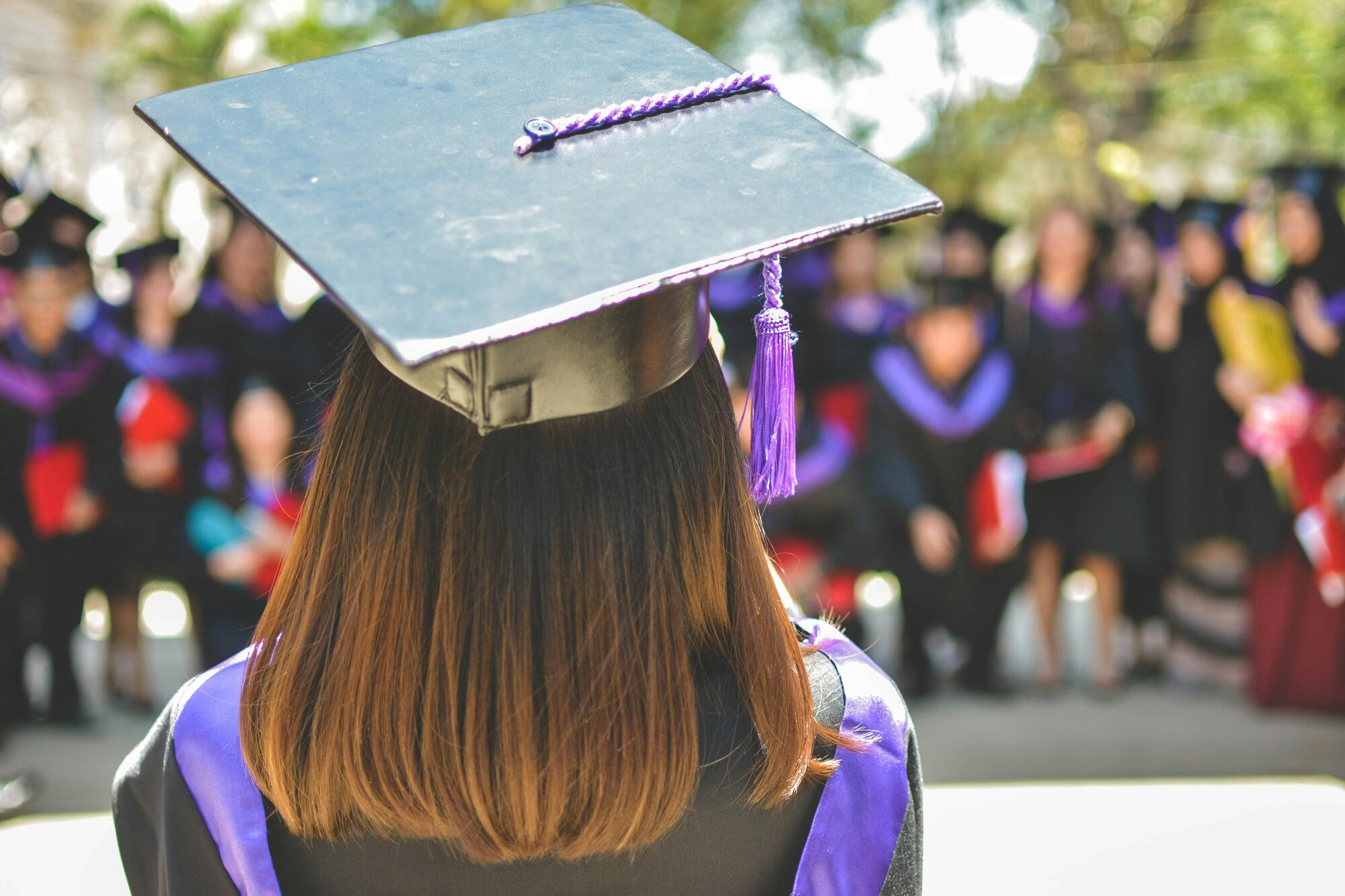 Higher education graduation ceremony with university students wearing caps and gowns